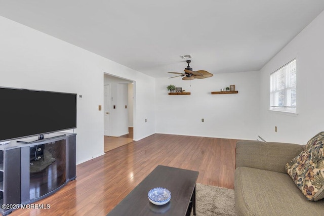 living room featuring hardwood / wood-style floors and ceiling fan