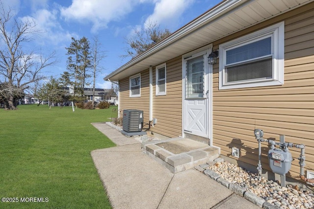 doorway to property featuring a yard and cooling unit