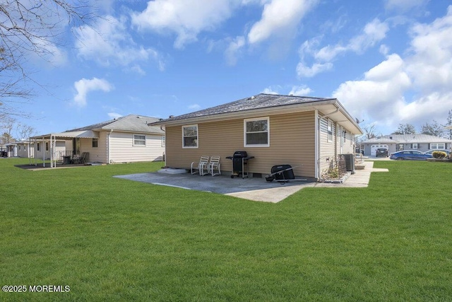 rear view of property featuring cooling unit, a patio, and a lawn