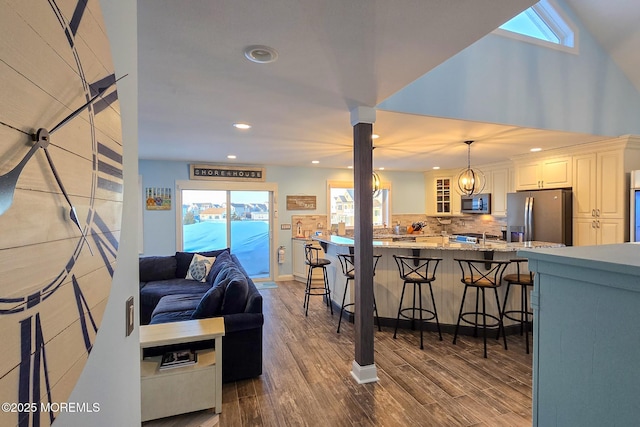 living room featuring wood-type flooring and vaulted ceiling