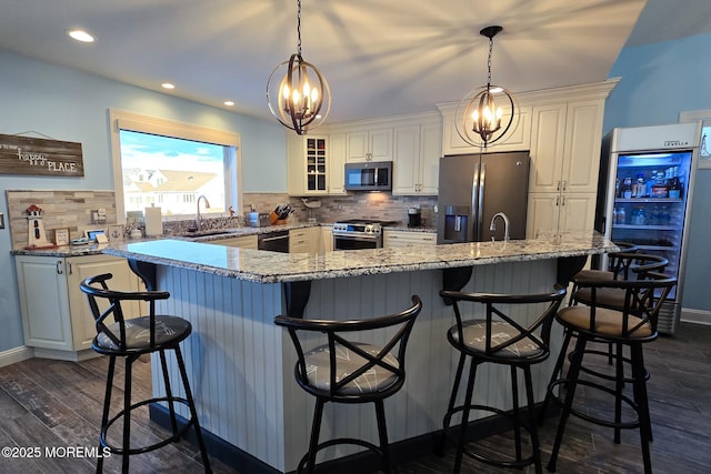 kitchen with tasteful backsplash, a kitchen bar, appliances with stainless steel finishes, and sink