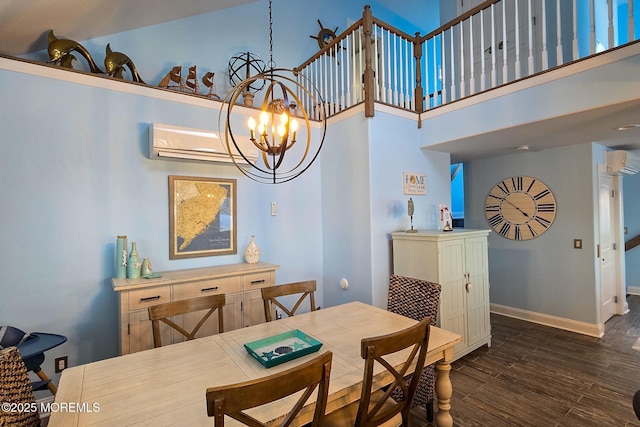 dining room with dark wood-type flooring, a towering ceiling, a chandelier, and a wall unit AC