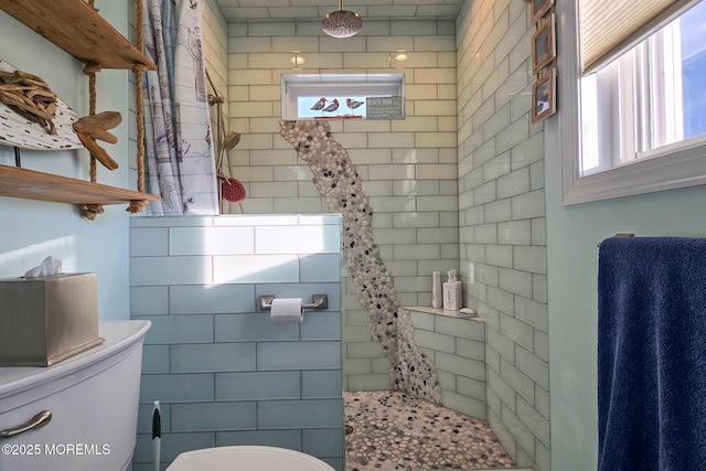 bathroom with toilet and a tile shower