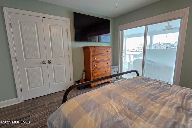 bedroom with access to exterior, dark hardwood / wood-style floors, and a closet