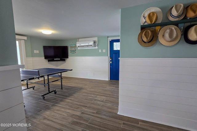 game room with plenty of natural light, dark hardwood / wood-style flooring, and a wall mounted AC