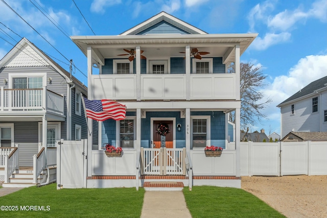 view of front of house featuring a front lawn, a balcony, and ceiling fan