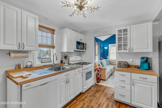 kitchen with white appliances, wooden counters, and white cabinets