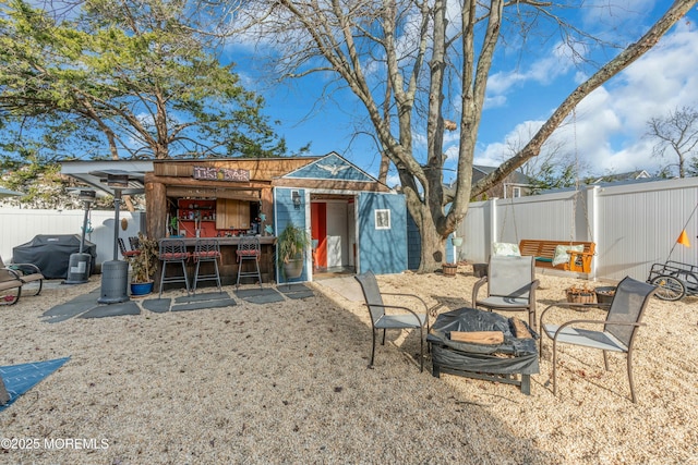 rear view of property featuring an outbuilding and an outdoor fire pit