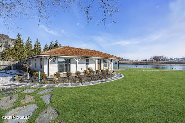 rear view of property with a water view and a lawn