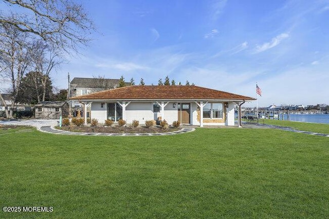 view of front of house featuring a front lawn and a water view