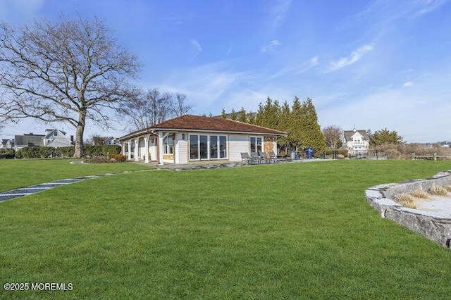 rear view of house featuring a lawn