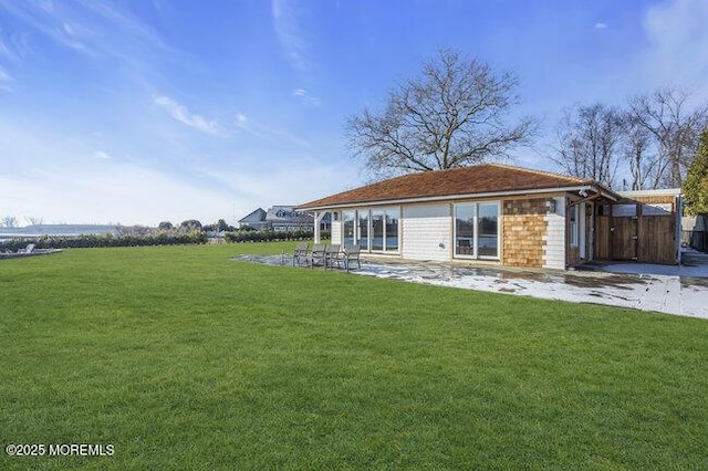 rear view of property with a lawn