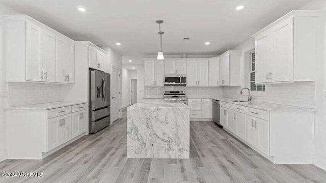 kitchen with stainless steel appliances, white cabinets, a center island, and pendant lighting