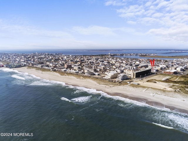 drone / aerial view featuring a beach view and a water view