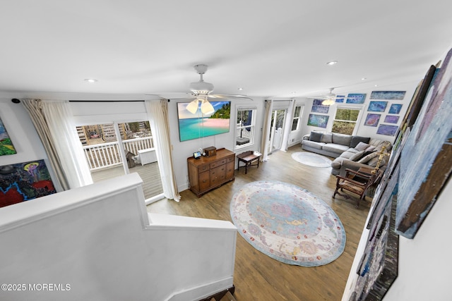 living room with light hardwood / wood-style floors, ceiling fan, and vaulted ceiling