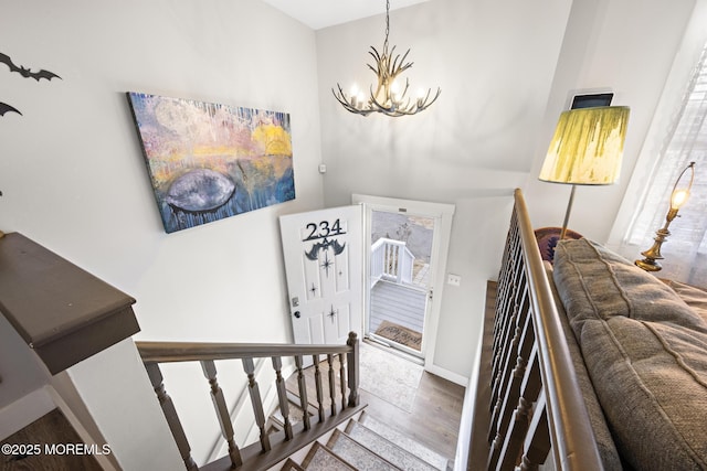 staircase with an inviting chandelier and hardwood / wood-style flooring