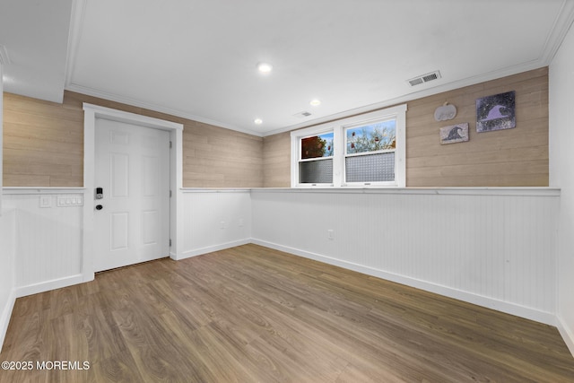 spare room featuring ornamental molding and hardwood / wood-style flooring