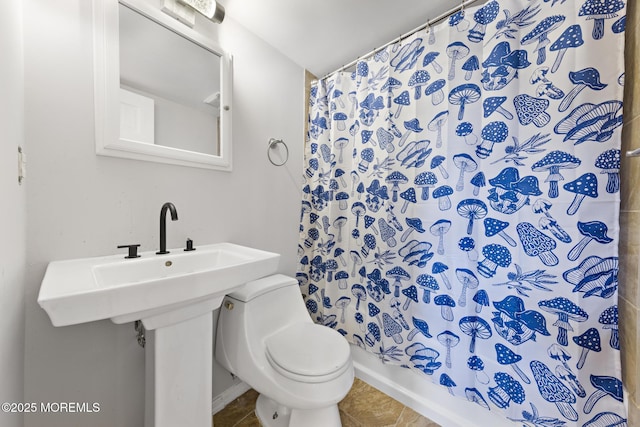 bathroom featuring toilet, tile patterned flooring, and a shower with curtain