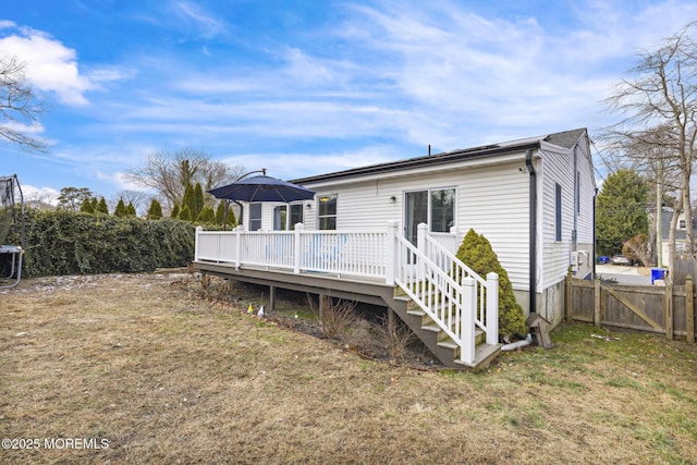 rear view of property with a lawn and a wooden deck