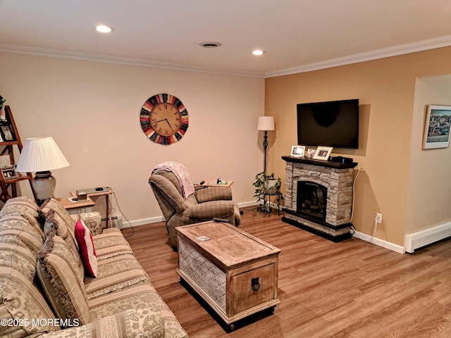 living room featuring a fireplace, ornamental molding, and hardwood / wood-style floors