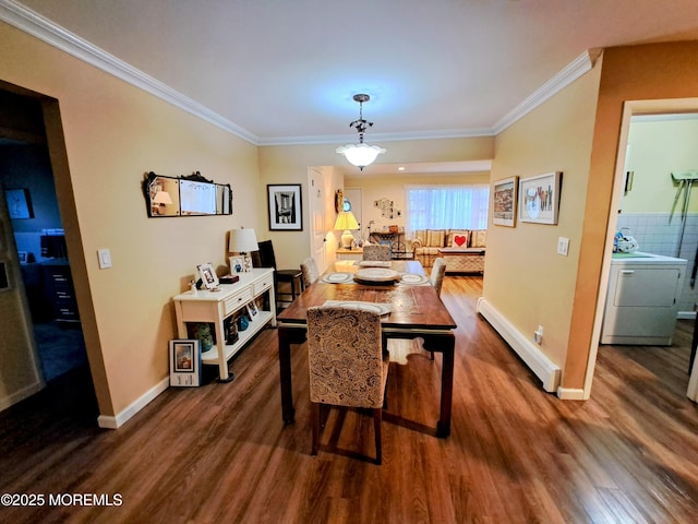 dining room featuring dark wood-type flooring, crown molding, baseboard heating, and sink