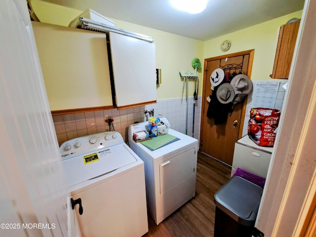 clothes washing area with dark wood-type flooring, cabinets, tile walls, and washer and clothes dryer