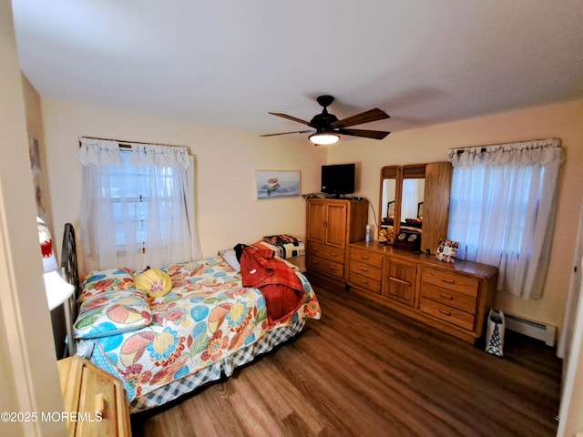 bedroom with ceiling fan, a baseboard heating unit, and dark hardwood / wood-style floors