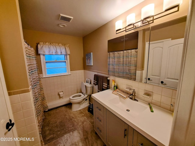 bathroom with tile walls, toilet, and vanity