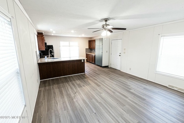 kitchen featuring kitchen peninsula, ceiling fan, hardwood / wood-style flooring, and ornamental molding