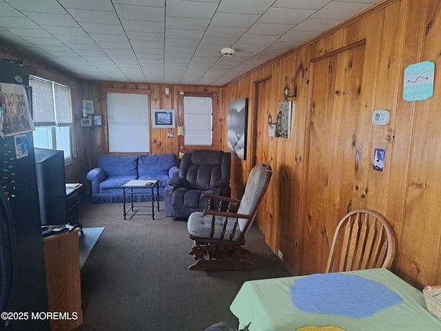 carpeted living room with wooden walls