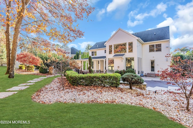 rear view of property featuring a patio area and a lawn