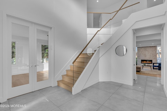 staircase featuring french doors and a fireplace