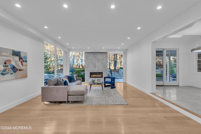 living room with light hardwood / wood-style flooring and a tile fireplace