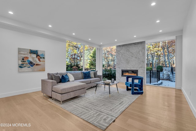 living room with light wood-type flooring and a tile fireplace