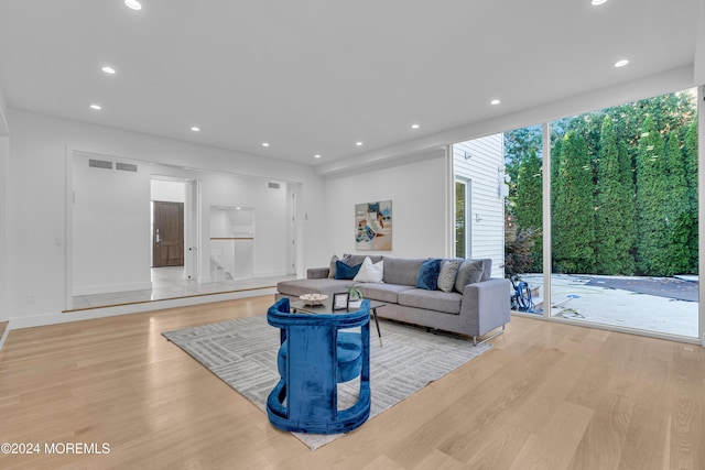 living room featuring light wood-type flooring and floor to ceiling windows