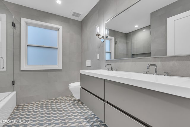 full bathroom featuring tile walls, toilet, a wealth of natural light, separate shower and tub, and vanity