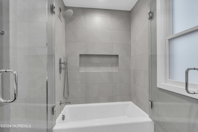 bathroom featuring shower / bath combination with glass door