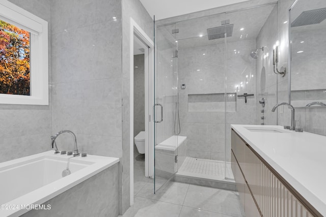 full bathroom featuring tile patterned flooring, tile walls, toilet, separate shower and tub, and vanity