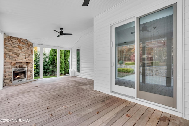 wooden deck featuring an outdoor stone fireplace and ceiling fan