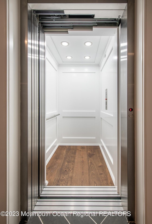 room details with elevator and hardwood / wood-style flooring