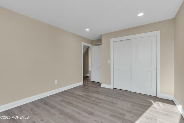 unfurnished bedroom featuring light wood-type flooring and a closet