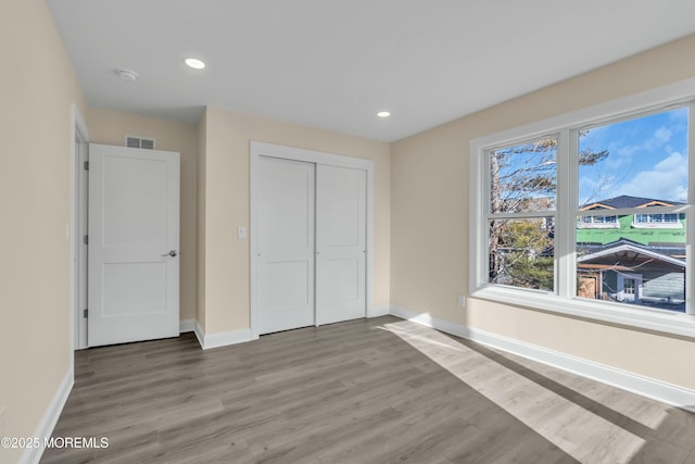 unfurnished bedroom featuring a closet and wood-type flooring