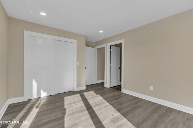 unfurnished bedroom with hardwood / wood-style flooring and a closet