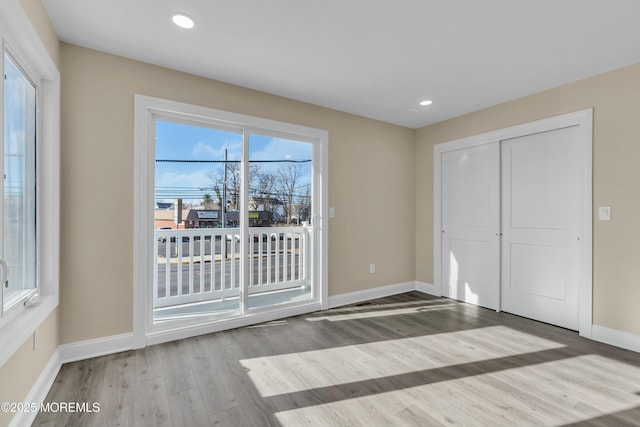 unfurnished bedroom with a closet, access to outside, and light hardwood / wood-style flooring