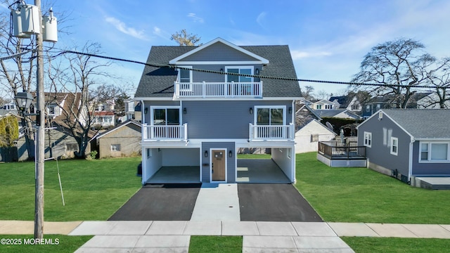 beach home with a balcony and a front yard