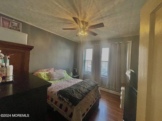 bedroom featuring ceiling fan, dark wood-type flooring, and a baseboard radiator