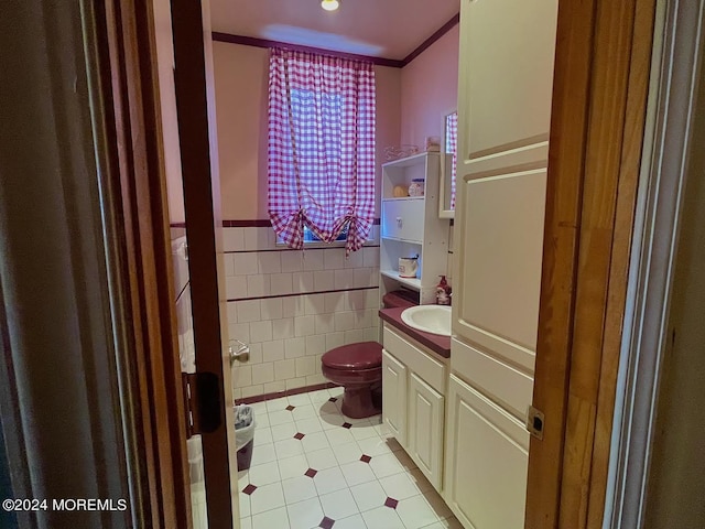 bathroom with toilet, tile patterned flooring, tile walls, crown molding, and vanity