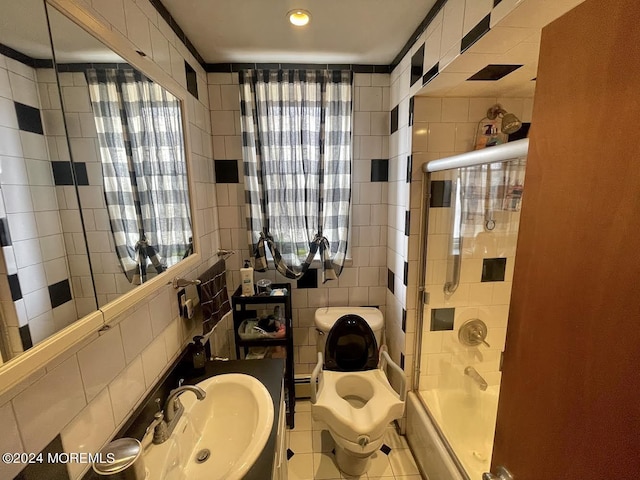 full bathroom featuring tile patterned flooring, combined bath / shower with glass door, tile walls, a baseboard heating unit, and sink