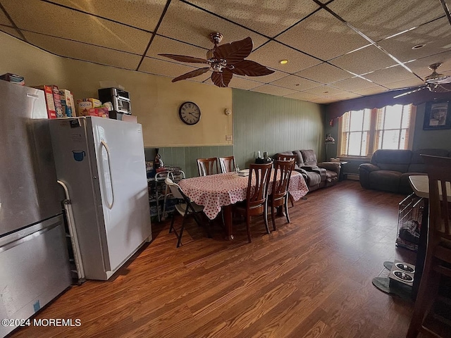 dining room with ceiling fan, wood-type flooring, and a drop ceiling