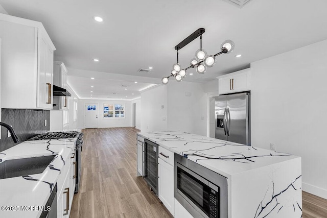 kitchen featuring stainless steel fridge with ice dispenser, pendant lighting, white cabinets, and a center island